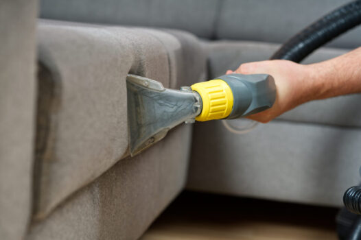 Sofa chemical cleaning with professionally extraction method. Wet textile sofa cleaning. home cleaning service. cleaning sofa with washing suction cleaner closeup.